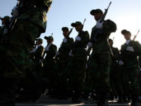 ** FILE ** Members of Iranian Corps Guards of the Islamic Revolution forces parade during large-scale military parades in Tehran to mark the 27th anniversary of the Iraqi invasion of Iran that sparked the bloody 1980-88 war, in Tehran, Iran in this photo taken on Saturday Sep. 22, 2007. They own car factories and construction firms, operate newspaper groups and oil fields and increasingly, serve in parliament or become provincial governors. To supporters, the Revolutionary Guards are the cream of the country's talent. (AP Photo/Hasan Sarbakhshian,file)