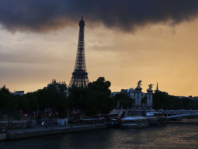 Dark clouds and rain are pictured over Paris and the Eiffel tower at sunset on May 19, 201