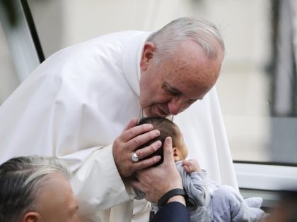 PHILADELPHIA, PA - SEPTEMBER 26: Pope Francis bends over to kiss a small child as he arrives at Independence Mall to watch Pope Francis speak in Philadelphia onSeptember 26, 2015 in Philadelphia., Pennsylvania. After visiting Washington and New York City, Pope Francis concludes his tour of the U.S. with events …