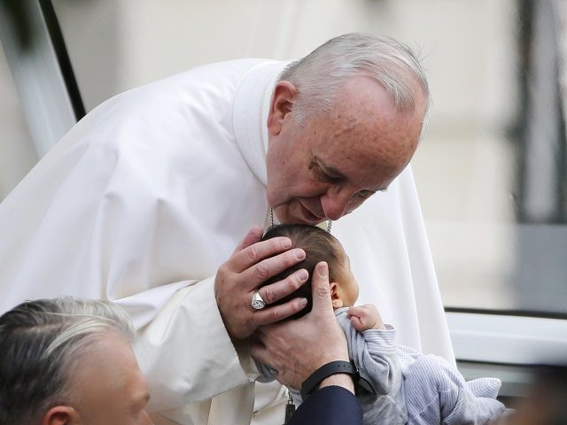 PHILADELPHIA, PA - SEPTEMBER 26: Pope Francis bends over to kiss a small child as he arriv