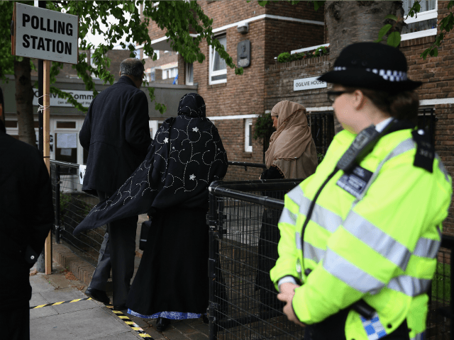 A police officer stands outside a polling station at a community hall in Tower Hamlets on