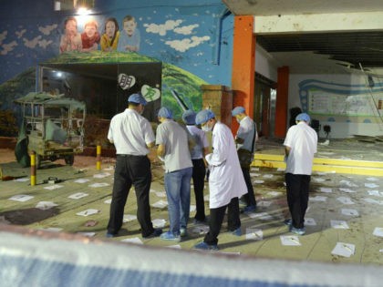 Police officers examine the entrance to a kindergarten in Xuzhou in Jiangsu Province, east