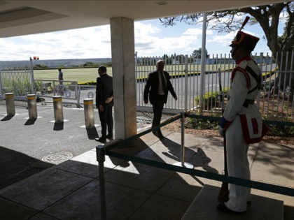 Security officers stand guard at the main entrance of the Alvorada Palace after a minor rammed a car through the gate Wednesday night, in Brasilia, Brazil, Thursday, June 29, 2017. Security forces detained a the minor who allegedly wanted to reach the presidential palace. A statement from the president's office …