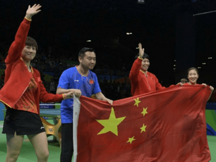 (L-R) China's Ding Ning, coach Kong Linghui, Li Xiaoxia and Liu Shiwen posing with the national Chinese flag after winning gold medals in the women's team final table tennis at the Riocentro venue during the Rio 2016 Olympic Games in Rio de Janeiro