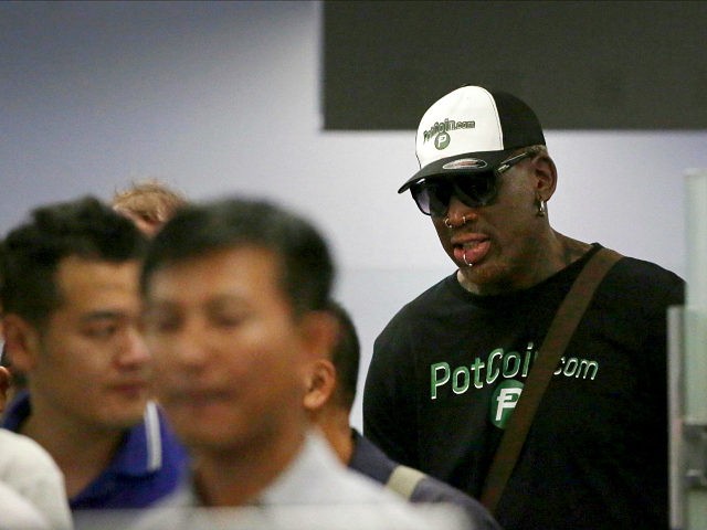 Former NBA basketball star Dennis Rodman, right, is seen in a security queue at Beijing's