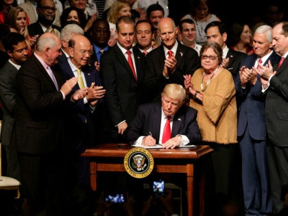 President Donald Trump signs an executive order on a revised Cuba policy aimed at stopping the flow of U.S. cash to the country's military and security services while maintaining diplomatic relations, Friday, June 16, 2017, in Miami. From left are, Agriculture Secretary Sonny Perdue, Commerce Secretary Wilbur Ross, Rep. Mario …