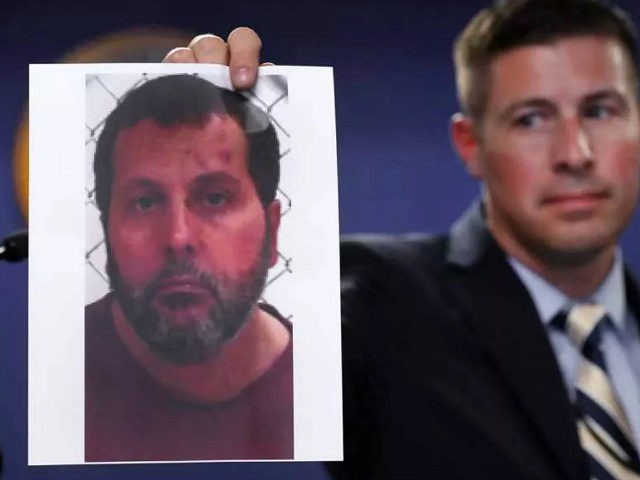 Timothy Wiley, FBI public affairs specialist, holds a photo Amor Ftouhi after a news confe