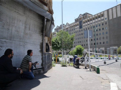 An undercover Iranian policeman (L) holds a weapon outside the Iranian parliament in the capital Tehran on June 7, 2017 during an attack on the complex. The Islamic State group claimed its first attacks in Iran as gunmen and suicide bombers killed at least five people in twin assaults on …