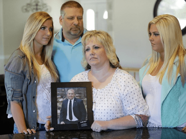 FILE - Laurie Holt holds a photograph of her son Josh Holt, while daughters Jenna, left, Katie, right, and husband Jason look on at her home Wednesday, July 13, 2016, in Riverton, Utah. Josh Holt, an 24-year-old American man jailed in Venezuela has been allowed to meet with U.S. diplomats …