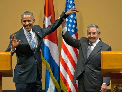 FILE - In this March 21, 2016 file photo, Cuban President Raul Castro, right, lifts up the