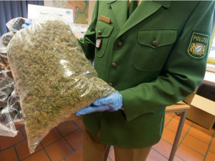 A policeman shows a bag with seized marijuana during a press conference in Passau, southern Germany, on October 20, 2016. 230kg Marjuana were found in tubes of a truck. / AFP / dpa / Armin Weigel / Germany OUT (Photo credit should read ARMIN WEIGEL/AFP/Getty Images)