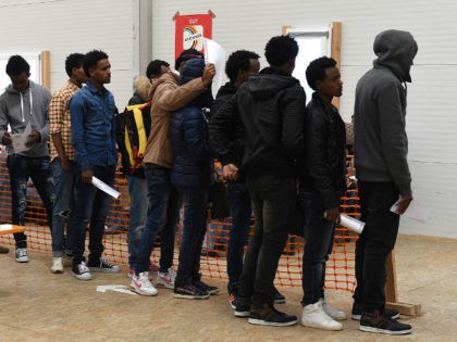 Migrants wait for a first registration at the registration point for asylum seekers in Erding near Munich, southern Germany, on November 15, 2016. The refugees from Eritrea came by plane from Italy. / AFP / CHRISTOF STACHE (Photo credit should read CHRISTOF STACHE/AFP/Getty Images)