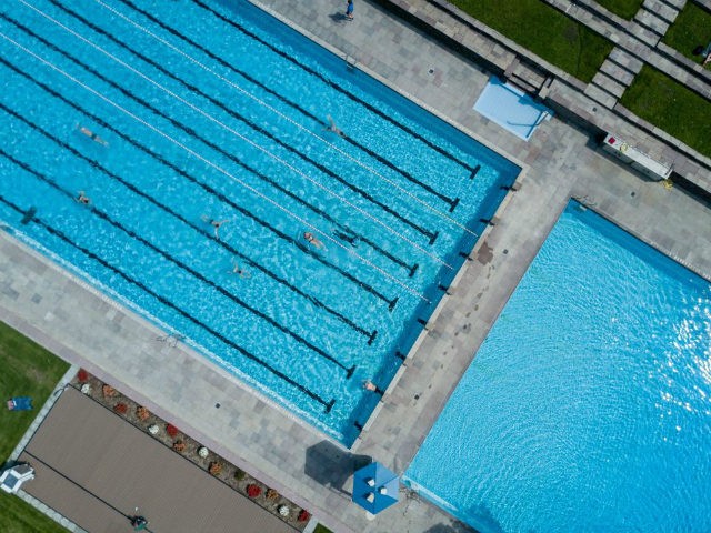 Picture taken with a drone shows bathers swimming at the Kaifu-Bad public pool in Hamburg, northern Germany, where temperatures reached up to 26 degrees Celsius on May 17, 2017. / AFP PHOTO / dpa / Axel Heimken / Germany OUT (Photo credit should read AXEL HEIMKEN/AFP/Getty Images)