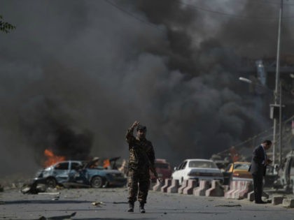 An Afghan security force member stands at the site of a car bomb attack in Kabul on May 31