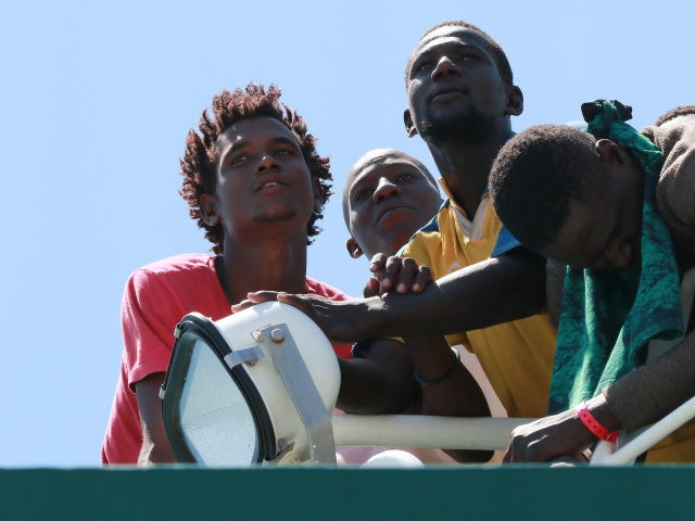 Migrants wait to disembark from the Spanish Guardia Civil Rio Segura Patrol Ship with 1,21