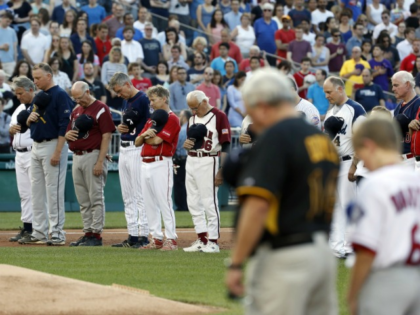 Members of both congressional teams bow their heads for a moment of silence for Rep. Steve Scalise, R-La., before the congressional baseball game Thursday in Washington. alex brandon/Associated Press