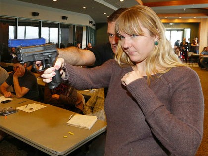 WEST VALLEY CITY, UT - DECEMBER 27: Joanna Baginska (R), a fourth grade teacher at Odyssey Charter School in American Fork, Utah is shown how to handle a 40 cal. Sig Sauer by firearm instructor Clark Aposhian at a concealed-weapons training class to 200 Utah teachers on December 27, 2012 …