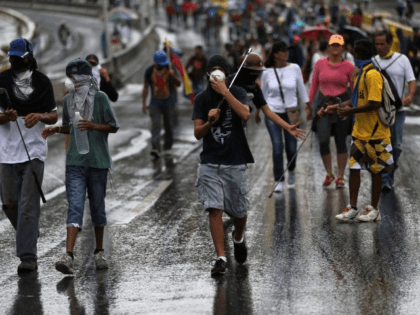 Demonstrators walk under the rain prior clashes with authorities, in Caracas, Venezuela, J