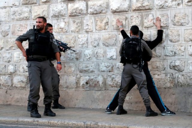 Israeli borderguards search a Palestinian man outside Damascus Gate in Jerusalem's Old Cit