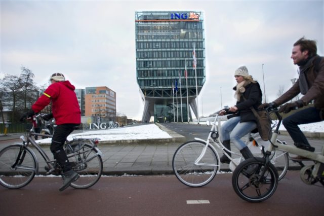 People cycle past the headquarters of the Dutch banking and insurance group ING in Amsterd