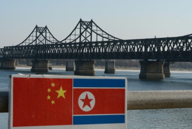A sign displaying the Chinese (L) and North Korean (R) flags is pictured by the Sino-Korea
