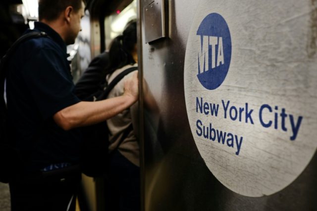 Passengers enter a Metropolitan Transportation Authority (MTA) subway in New York City