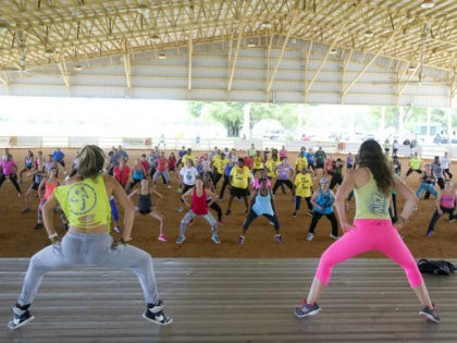 Zumba Fitness instructors Andrea Ceballos, left, and Michelle Donoso, right, lead a crowd in a workout during a Fitness Dance Party, Saturday, July 25, 2015, at Tropical Park in Miami. The event promoted health and fitness activities as part of Miami-Dade County's Park and Recreation Month. (AP Photo/Wilfredo Lee)