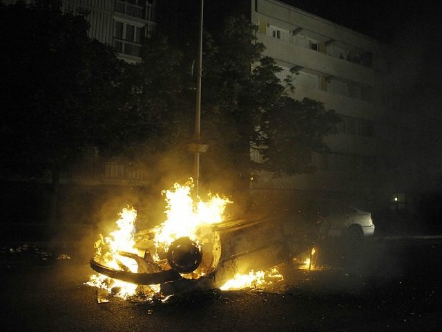 A car burns in a street following clashes