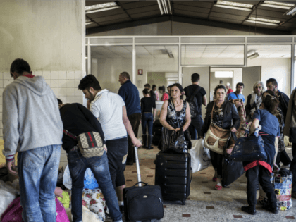 Eastern European migrants wait to temporarily settle in a locale in Decines after staying in buildings belonging to the army and the diocese of Lyon, on April 21, 2015.