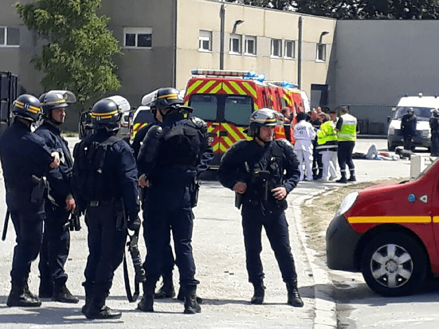 Police officers and emergency workers intervene after clashes between migrants involving E