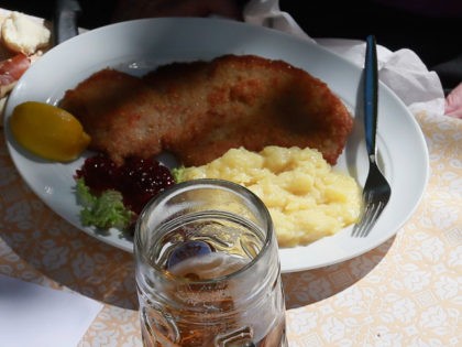 MUENCHEN, GERMANY - SEPTEMBER 18: People eat German Wiener Schnitzel and drink beer under