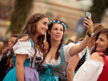 MUNICH, GERMANY - SEPTEMBER 19: Revelers dressed in Bavarian folk outfits pose for selfies