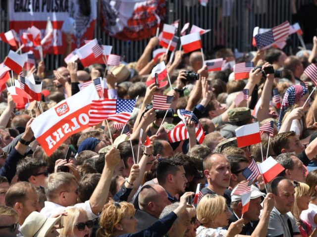 Spectators wave as US President Donald Trump gives a speech in front of the Warsaw Uprisin