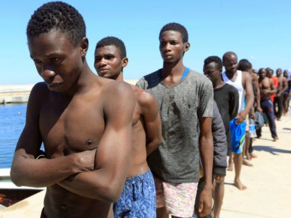 Illegal migrants from Africa, attempting to reach Europe, walk towards a detention center off the coastal town of Guarabouli, 60 kilometres (36 miles) east of the capital, on July 8, 2017. Thirty-five migrants, including seven children, were feared drowned after their inflatable craft sank off the Libyan coast, the coastguard …