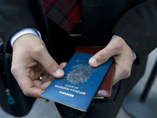 Filipe Diniz, who traveled from Brazil, readies his passport he'll use to claim his ticket