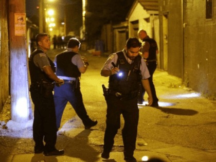 Chicago police search for evidence after a shooting in a Chicago alley this month, part of a surge in gun violence plaguing the US city