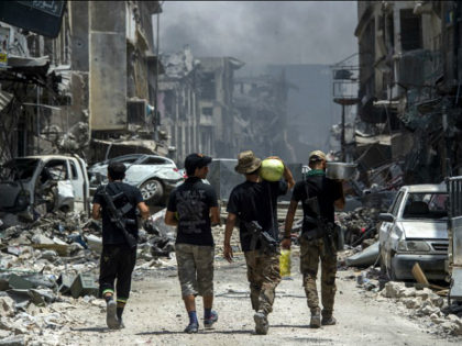 Iraqi Counter-Terrorism Services (CTS) members carry food as they walk in the Old City of