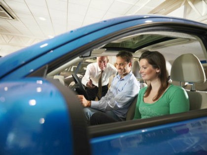 Salesman shows customers a car Monty Rakusen / Cultura Creative