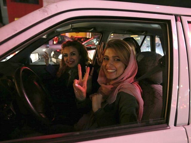 Women in a car flash the 'V for Victory' sign as they celebrate on Valiasr street in north