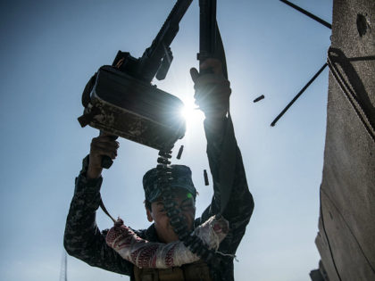 MOSUL, IRAQ - APRIL 06: An Iraqi federal policeman fires a machine gun at an Islamic State