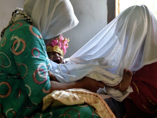 In this photograph taken on February 20, 2017, toddler Salsa Djafar cries as a traditional healer conducts a circumcision in Gorontalo, in Indonesia's Gorontalo province. Female circumcision -- also known as female genital mutilation or FGM -- has been practised for generations across Indonesia, which is the world's biggest Muslim-majority …