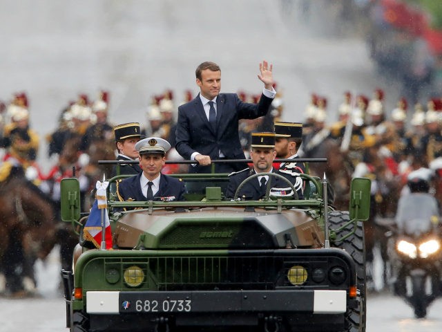 Newly elected French president Emmanuel Macron waves as he parades in a military car on th
