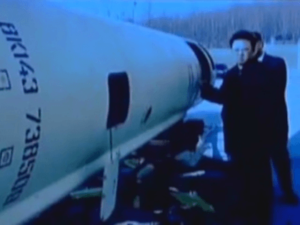 Former North Korean leader Kim Jong Il stands near what appears to be a Scud-B missile.