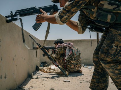 RAQQA, SYRIA, JUNE 12: SDF soldiers take aim at a minaret where they believe an IS sniper