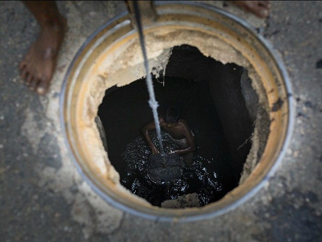 DHAKA, BANGLADESH - MAY 03: A sewer cleaner of Dhaka City Corporation cleaning out the cit