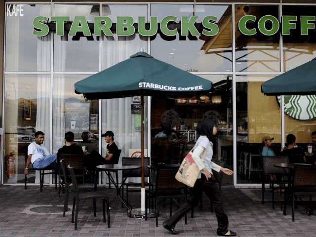 A Muslim woman walks past a Starbucks Coffee shop in Rawang outside Kuala Lumpur, Malaysia