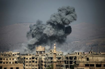 Smoke rises from buildings following a reported air strike on the rebel-held town of Ain T