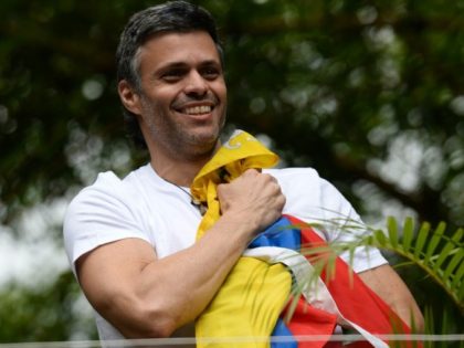 Venezuelan opposition leader Leopoldo Lopez holds a Venezuelan national flag against his chest, as he greets supporters gathering outside his house in Caracas after he was released from prison on July 8, 2017