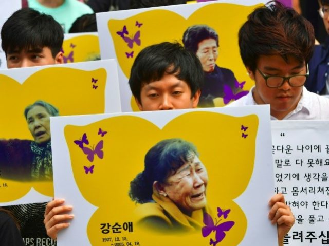 South Korean protesters hold placards showing portraits of former "comfort women&quot
