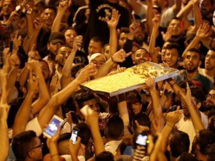 Palestinians celebrate by giving away sweets outside Jerusalem's Al-Aqsa mosque compound on July 27, 2017, after Israeli police removed the last new security barriers from the entrances